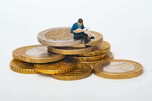 man sitting on pile of coins